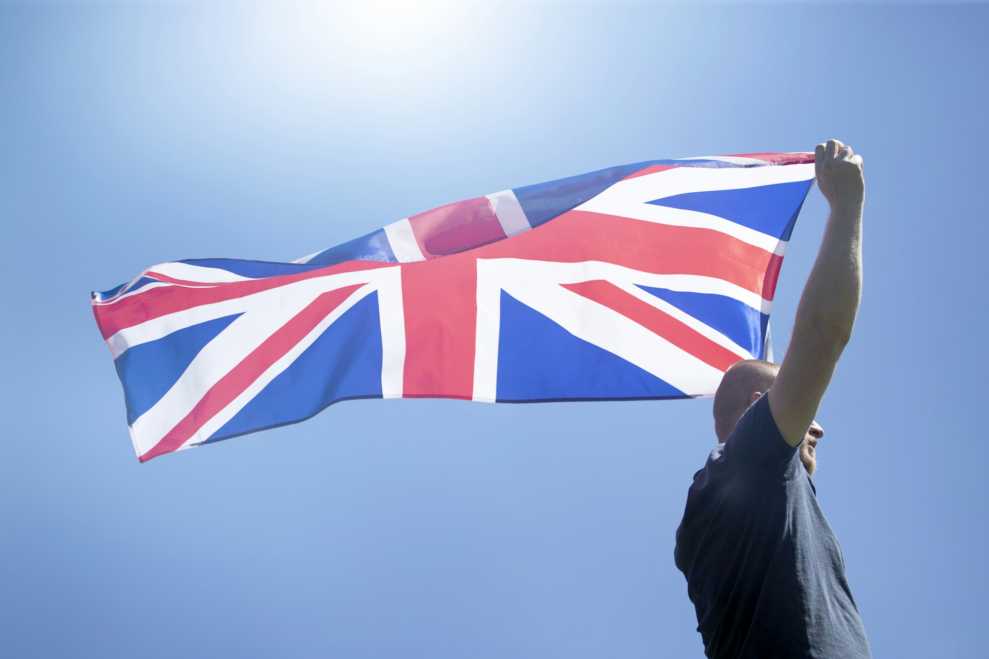 Patriot man holding the United Kingdom flag.