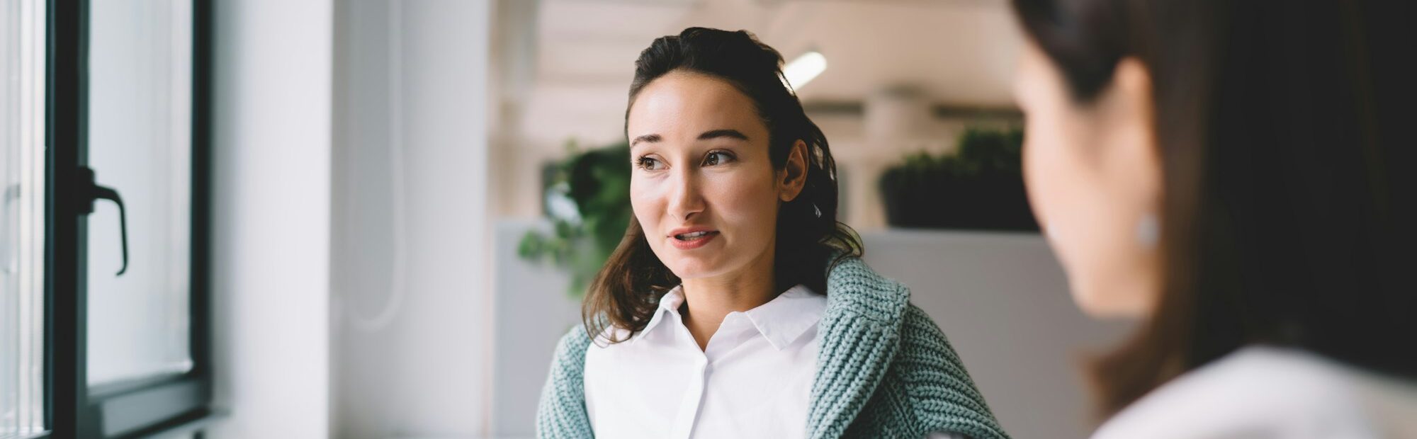 Young office employee discussing project with female colleague
